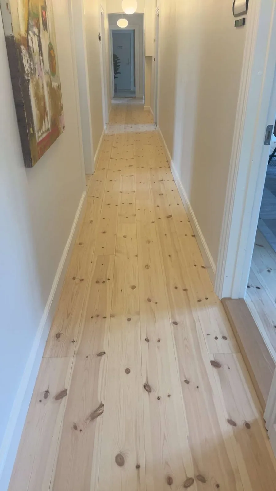 Langt plankegulv i lys hallway